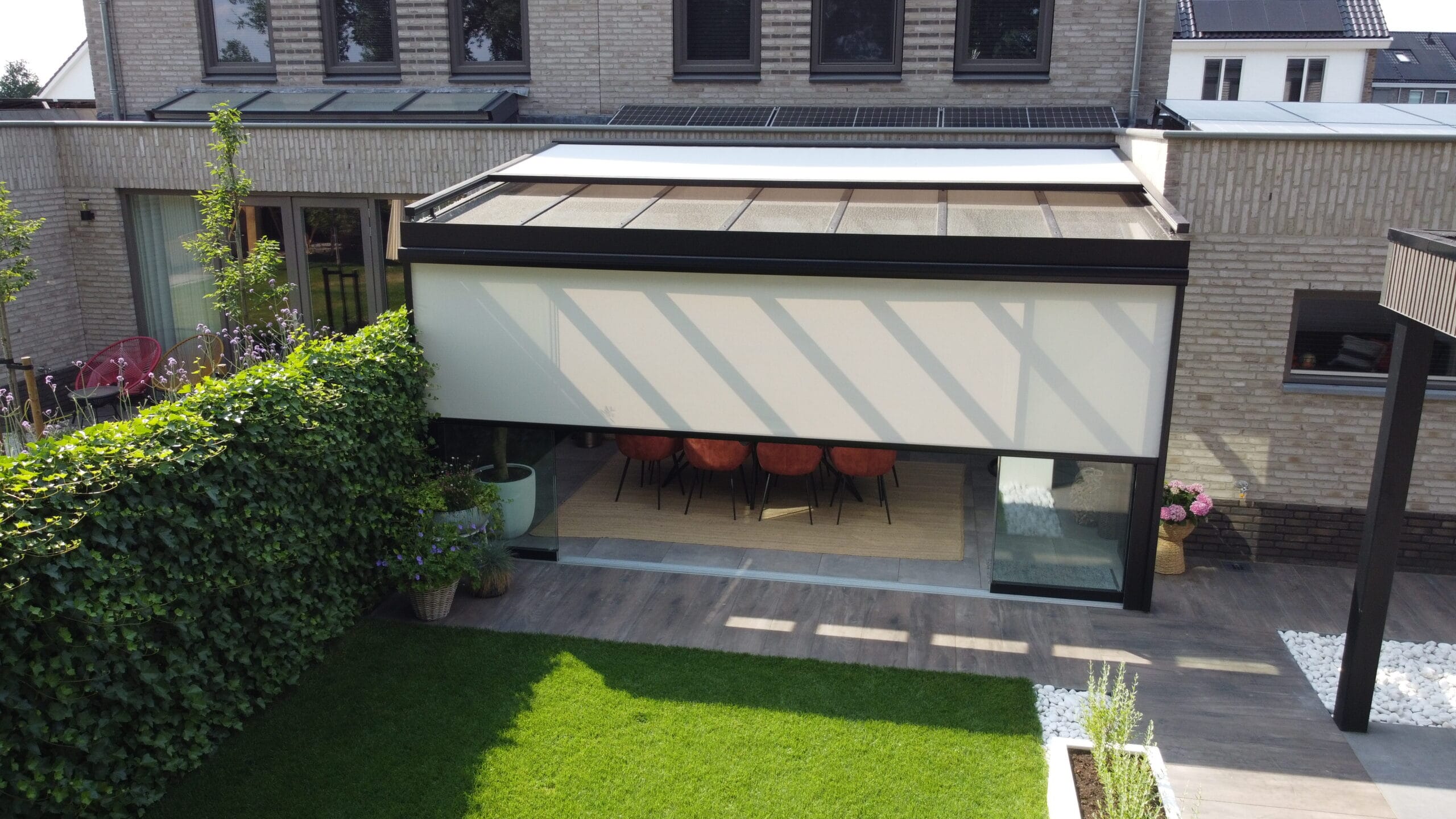 Een veranda van MB Veranda met zonwering en screens Een veranda van MB Veranda met zonwering en screens