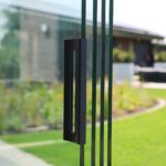 Glazen schuifwanden onder bestaand afdak met handgrepen